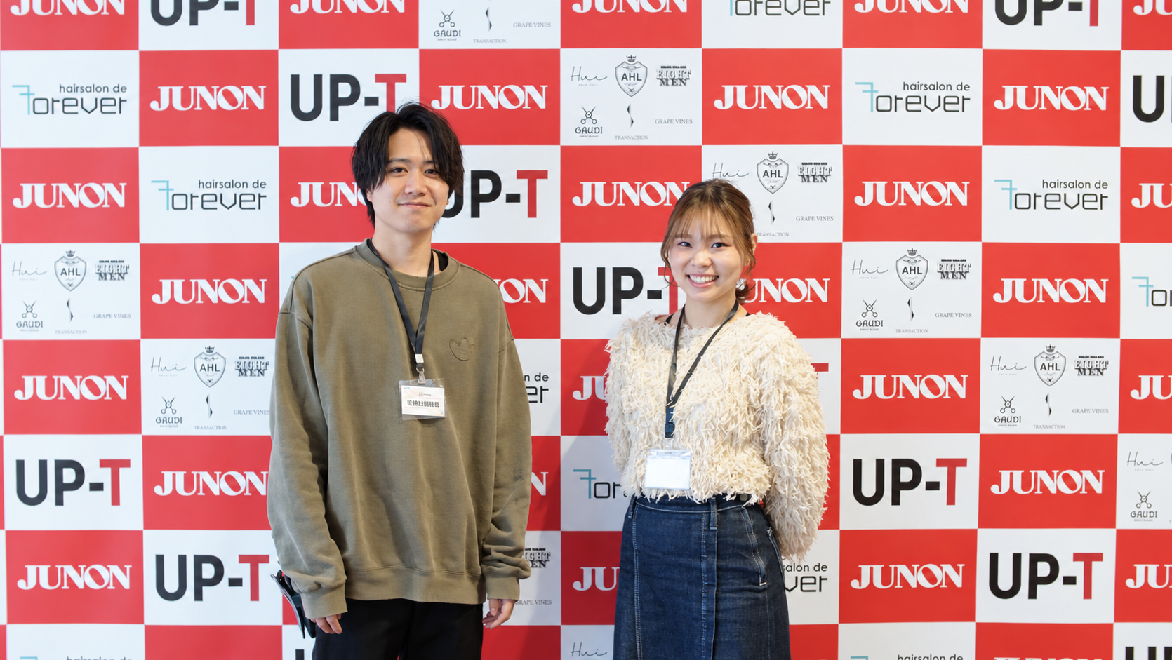 イベント会場で笑顔を見せる二人のスタッフ